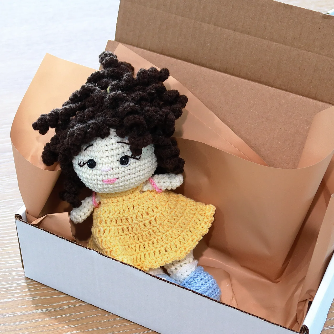 Lori doll packed in tissue in a white mailer