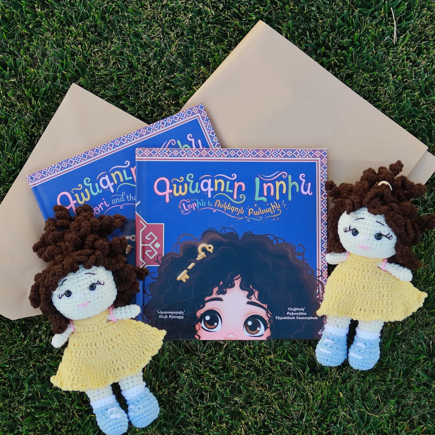 Two Lori dolls with the book on grass